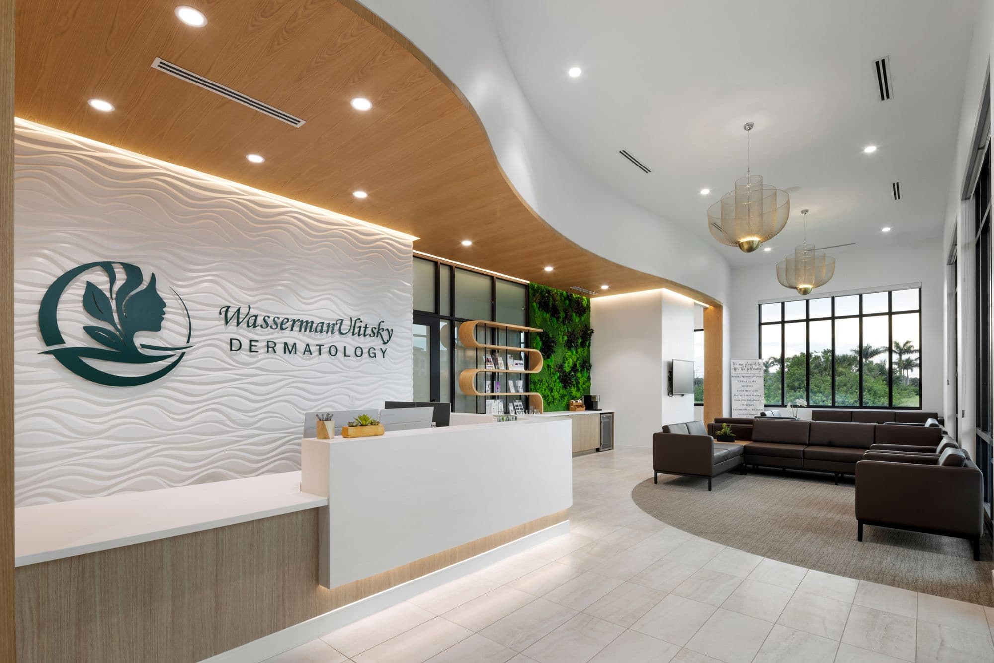 Dermatology practice reception with a wave-textured logo wall, curved wood ceiling soffit, moss wall and waiting seating